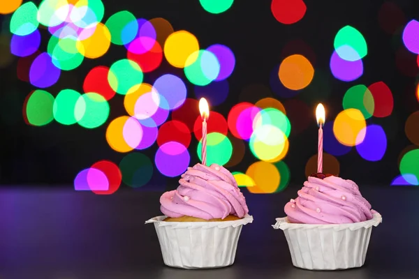 Tasty Birthday cupcakes on table against defocused lights — Stock Photo, Image