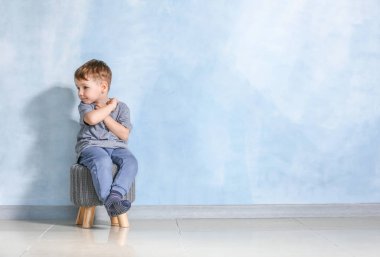 Otistik bozukluğu olan küçük çocuk ışık duvara yakın oturan