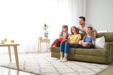 Evde televizyon izleyen mutlu bir aile.