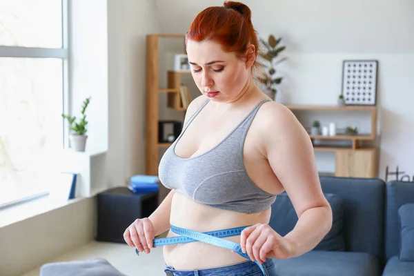 Overweight woman with measuring tape at home. Weight loss concept — Stock Photo, Image