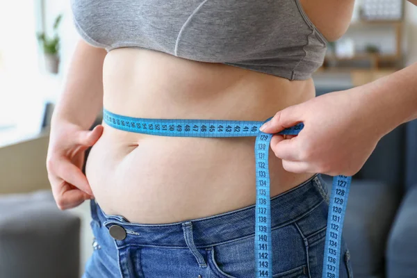 Nadváha žena s měřicí páskou doma, uzavřena. Koncepce ztráty váhy — Stock fotografie