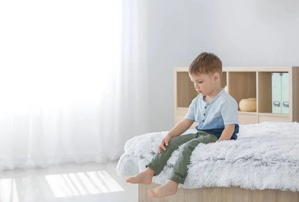 Little boy with autistic disorder sitting on bed at home — Stock Photo, Image