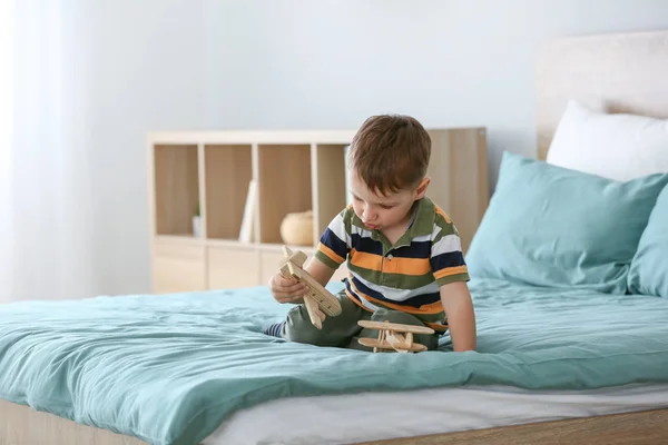 Little boy with autistic disorder playing on bed at home — Stock Photo, Image