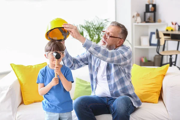 Grandfather teaching little boy to repair clock at home — Stock Photo, Image
