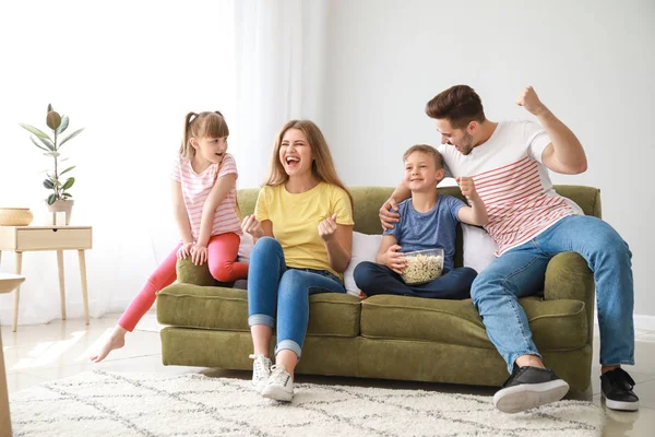 Happy family watching sports on TV at home — Stock Photo, Image