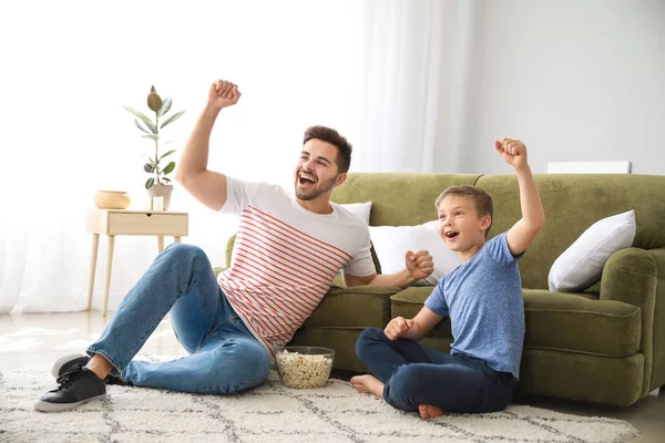 Pai com filho assistindo esportes na TV em casa — Fotografia de Stock