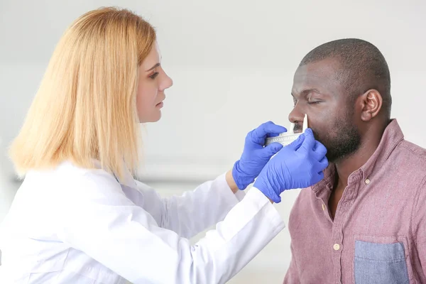 African-American man meeting with plastic surgeon before operation in clinic