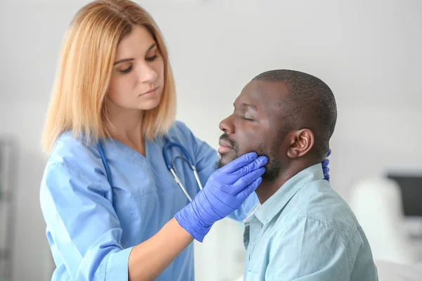 African-American man meeting with plastic surgeon before operation in clinic