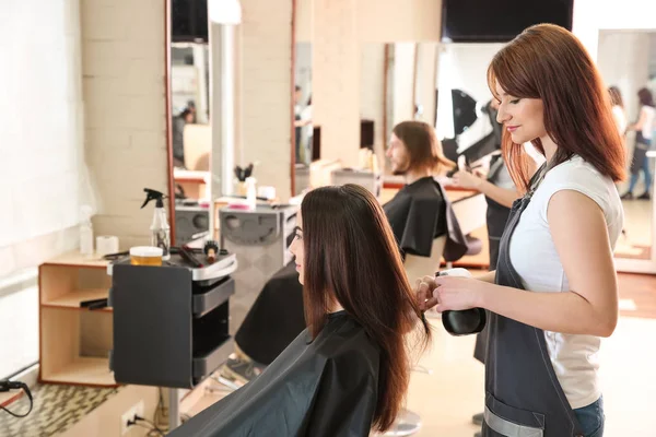 Cabeleireiro feminino trabalhando com cliente no salão — Fotografia de Stock