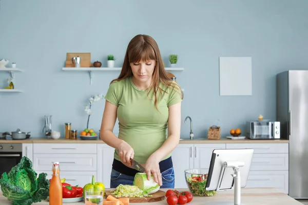 Młoda kobieta w ciąży gotowanie w kuchni — Zdjęcie stockowe