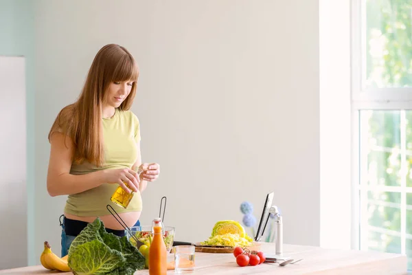 Schöne schwangere Frau macht gesunden Salat in der Küche — Stockfoto