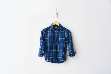 Beyaz duvarda giysi ile Askı