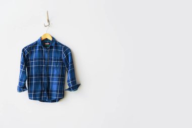 Beyaz duvarda giysi ile Askı