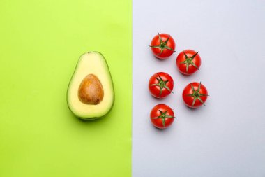 Taze avokado ve domates renkli arka planda