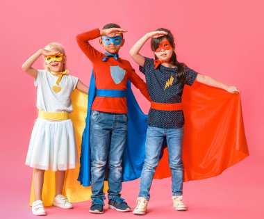 Cute little children dressed as superheroes on color background clipart