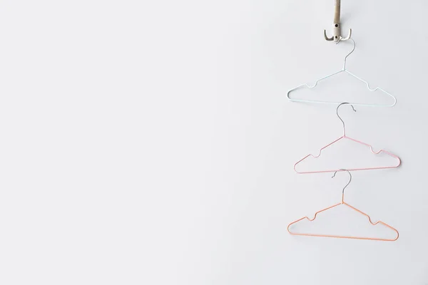 Clothes hangers on white wall — Stock Photo, Image