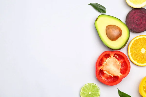 Fresh avocado, fruit and vegetables on light background — Stock Photo, Image