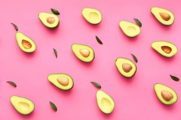 Halves of fresh avocados on color background — Stock Photo, Image