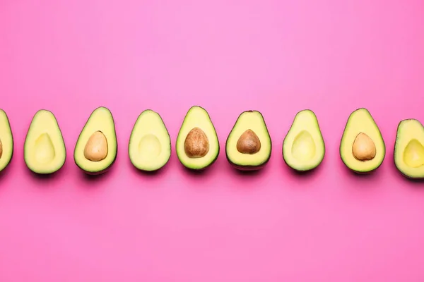 Helften van verse avocado's op kleur achtergrond — Stockfoto