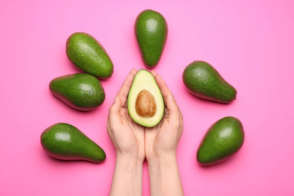 Mains féminines et avocats mûrs sur fond de couleur — Photo