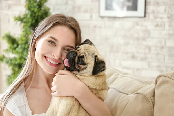 Hermosa mujer joven con lindo perro pug en casa — Foto de Stock