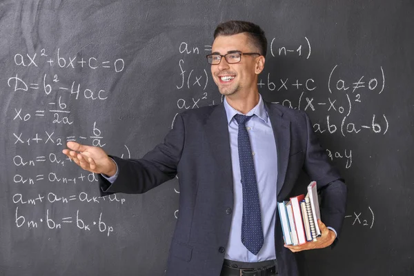 Beau professeur de mathématiques près du tableau noir en classe — Photo