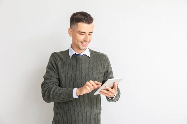 Pohledný mužský učitel s tabletovým počítačem na bílém pozadí — Stock fotografie