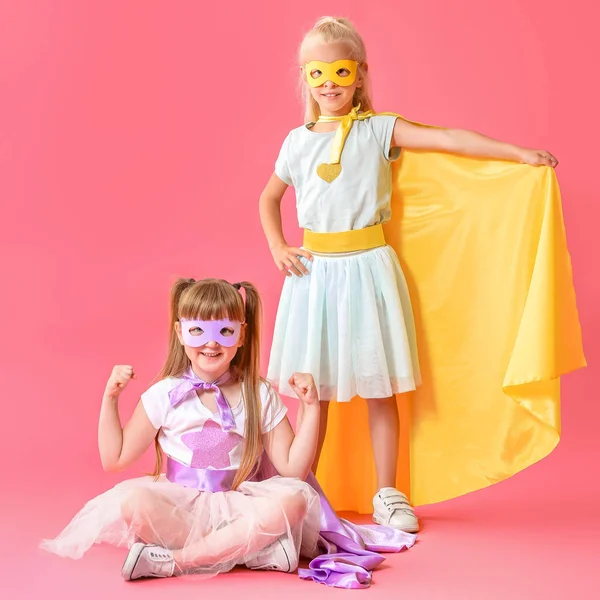 Renkli arka planda süper kahramanlar gibi giyinmiş sevimli küçük kızlar — Stok fotoğraf