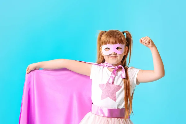 Linda niña vestida como superhéroe sobre fondo de color — Foto de Stock