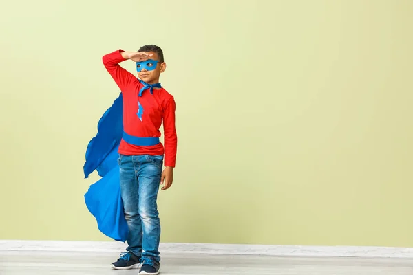 Cute African-American boy dressed as superhero near color wall — Stock Photo, Image