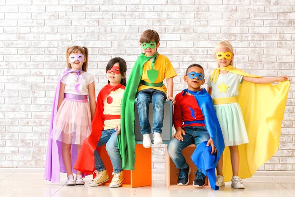 Śliczne małe dzieci ubrane jako Superbohaterowie w pobliżu muru ceglanego — Zdjęcie stockowe