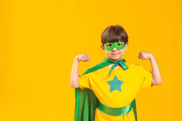 Carino bambino vestito da supereroe su sfondo di colore — Foto Stock