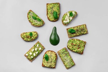 Gri arka planda farklı lezzetli avokado tost