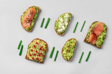 Gri arka planda farklı lezzetli avokado tost