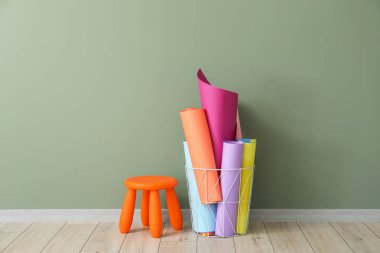 Çocuk odasında duvara yakın renkli kağıt ve tabure ile Sepet