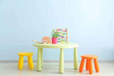Modern çocuk odasında duvara yakın masa ve tabureler