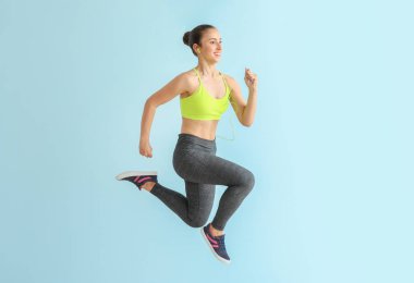Açık renk arka planda sportif kadın koşu