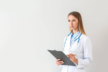 Hafif arka planda stetoskop ve pano ile kadın doktor