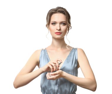 Beyaz arka planda parfüm şişesi olan güzel genç bir kadın.