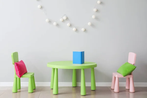 현대 어린이 방의 빛의 벽 근처의 의자와 테이블 — 스톡 사진