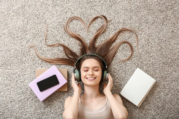 Beautiful young woman listening to audiobook at home — Stock Photo, Image