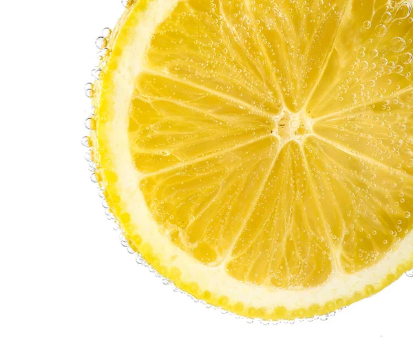 Спелый ломтик лимона в воде на белом фоне, крупным планом — стоковое фото