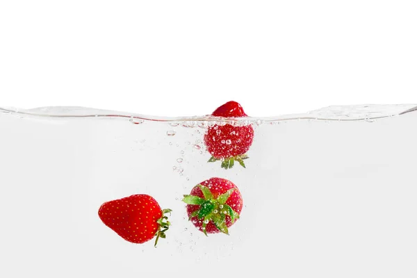 Caída de fresa dulce en agua sobre fondo blanco — Foto de Stock