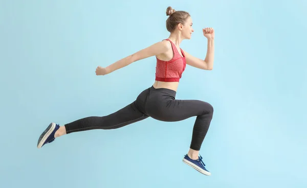 Jumping sportieve vrouw op lichte kleur achtergrond — Stockfoto