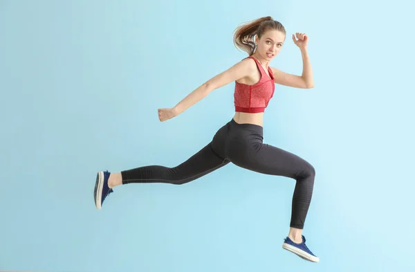 Jumping sporty woman on light color background — Stock Photo, Image