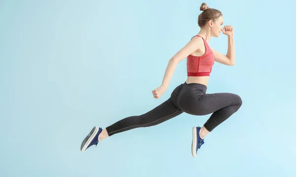 Jumping sportieve vrouw op lichte kleur achtergrond — Stockfoto