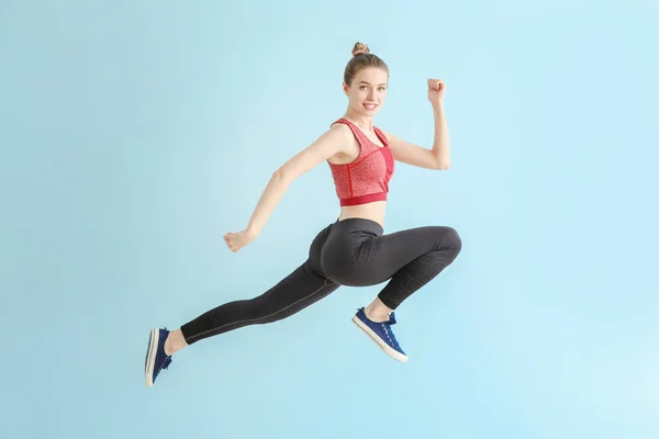 Springen sportliche Frau auf hellem Hintergrund — Stockfoto