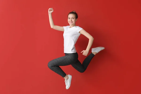점프 스포티 한 여자 에 색상 배경 — 스톡 사진