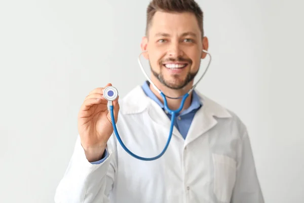 Médecin masculin avec stéthoscope sur fond clair — Photo