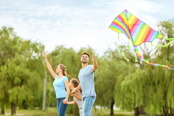 Happy family flying kite outdoors — Stock Photo, Image